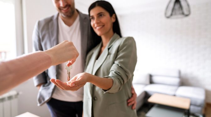 landlord handing couple keys